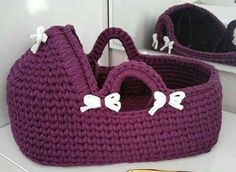 a crocheted purple basket with white bows on it and a gold toothbrush next to it