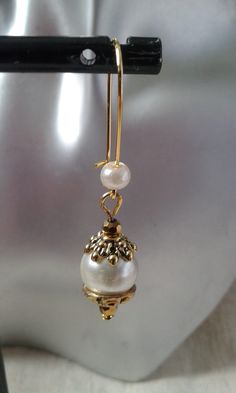 sleepy earrings made of ivory pearls and golden facets Dimensions: 2 cm long Delicate Handmade Gold Pearl Earrings, Gold Pearl Earrings With Brass Charm, Elegant Brass Pearl Earrings, Elegant Gold Pearl Earrings With Brass, Gold Pearl Clip-on Earrings, Gold Brass Pearl Earrings With Ear Wire, Formal Gold Dangle Pearl Earrings, Gold Pearl Earrings With Ear Wire, Gold Pearl Single Earring