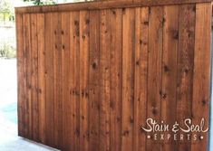 a wooden fence with the name stain & seal experts on it