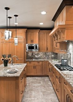 a kitchen with wooden cabinets and marble counter tops