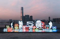 an illuminated display in front of a city skyline