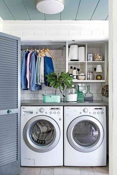 a washer and dryer in a small room with open shelves on the wall