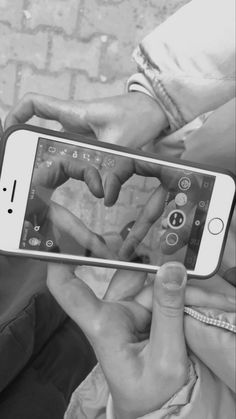 two people holding up their cell phones to touch the screen