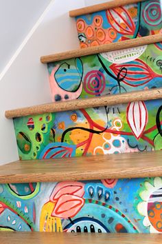 colorful painted steps leading up to the top of a stair case with flowers and leaves on it