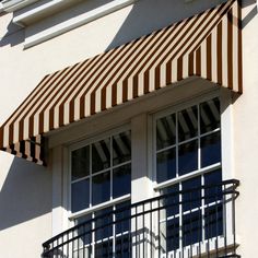 an awning on the side of a building that has two windows and balconies