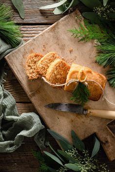 some food is laying out on a cutting board next to green leaves and greenery