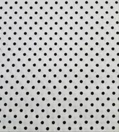 a close up view of a white surface with black dots