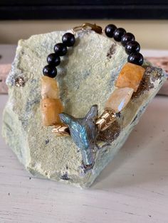 "Show your Nordic spirit with this gemstone and wood bracelet! The wolf head is hand-carved from labradorite. The wolf is accented with gorgeous yellow heliodor and black wood beads. The stones and beads are hand-strung by me on beading wire. The bracelet fastens with a lobster claw and is 7\" long. It will fit most wrists. The wolf is a symbol of guardianship, loyalty, ritual, and intelligence. The wolf reminds us to trust our instincts.  Fenrir is a giant wolf in Norse mythology and is a symbo Giant Wolf, Wolf Bracelet, Celtic Bracelet, Nordic Vikings, Symbols Of Strength, Wood Bracelet, Wolf Head, Norse Mythology, Beading Wire