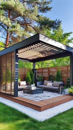 an outdoor living area with couches, tables and chairs in the grass next to trees