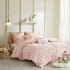 a bed with pink comforters and pillows in a room