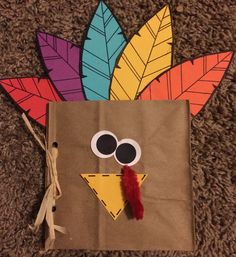 a paper bag with a turkey face on it and some leaves sticking out of it