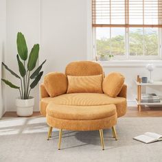 an orange chair and ottoman in a white room with a book on the floor next to it