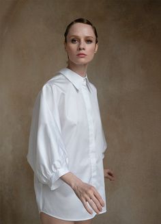 A white open-back shirt like no other - Prima Aurora dell’Etna. Inspired by the Aurora dell'Etna butterfly, which resides in the foothills of Mount Etna, this shirt blends style and comfort seamlessly. Gentle organic cotton provides ultimate comfort, while the butterfly's delicate elegance is reflected in the unique design with graceful 'wings.' The distinctive design of this blouse, featuring puff sleeves and a drawstring cutout, will accentuate your outfit at any occasion. Features: Oversized Timeless Spring Blouse With Relaxed Fit, Spring Timeless Blouse With Relaxed Fit, White Chic Shirt With Cuffed Sleeves, Timeless Tops For Summer Daywear, White Blouse With Cuffed Sleeves For Daywear, Timeless Summer Tops For Daywear, Timeless Relaxed Fit Tops For Spring, Timeless White Cotton Blouse, White Tops With Cuffed Sleeves And Shirttail Hem