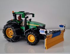 there is a toy tractor with a plow on the front and behind it's wheels