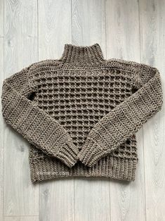 a knitted sweater laying on top of a wooden floor