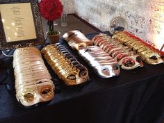 a table topped with lots of gold and silver items next to a framed sign that says happy new year