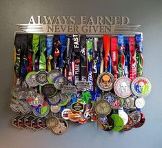 a bunch of medals hanging on a wall with the words always earn never given