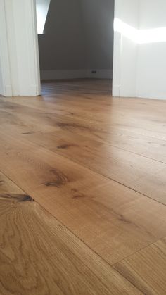 an empty room with hard wood floors and white walls