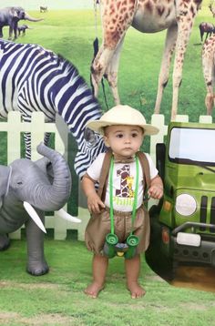 a baby standing in front of some fake animals