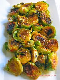 brussel sprouts with sesame seeds and seasoning on a white plate