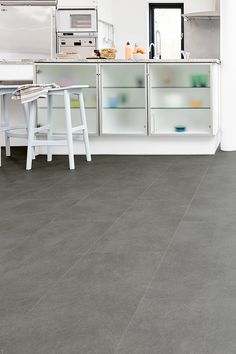 a kitchen with grey flooring and white cabinets