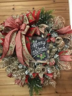 a christmas wreath hanging on the side of a door with ribbon and decorations around it