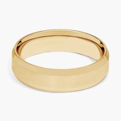 a yellow gold wedding ring on a white background