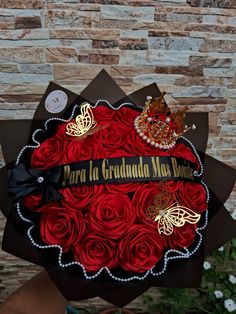 a bouquet of red roses in the shape of a heart with a tiara on top