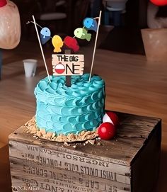 there is a blue cake on top of a wooden box that says tress one