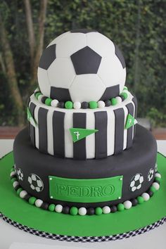 a three tiered cake with a soccer ball on top