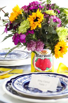 a vase filled with colorful flowers sitting on top of a blue and white table cloth