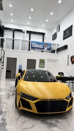 a yellow sports car is parked in a showroom