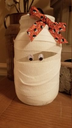 a white jar with eyes and a bow on it