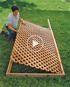 a man kneeling down next to a giant wooden board on the grass with an arrow in it