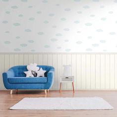 a blue chair sitting on top of a hard wood floor next to a white rug