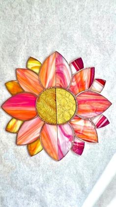 a flower made out of stained glass sitting on top of a table