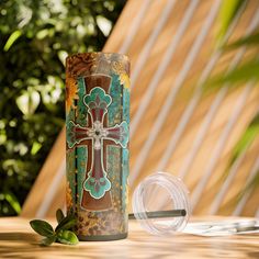 a cup sitting on top of a wooden table next to a leafy green plant