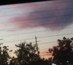 the sky is pink and blue as it appears to be dark in the distance, with power lines visible