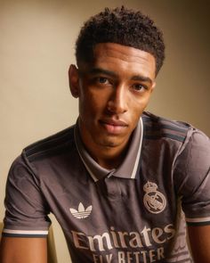 a young man in a soccer uniform poses for a photo