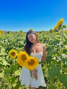 a woman standing in a sunflower field