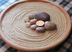 a bowl filled with rocks and a lit candle