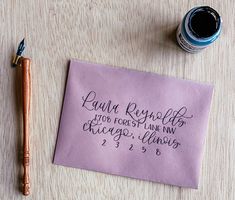 a piece of paper with writing on it next to a fountain pen and ink bottle