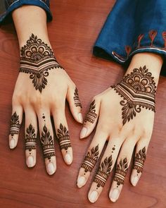 two hands with henna tattoos on them