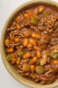 a bowl filled with beans and meat on top of a table