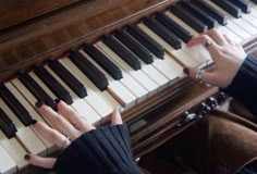 two hands are playing the piano with black and white keys