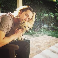 a man holding a small dog on his lap