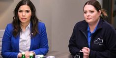 two women sitting at a table with beer cans