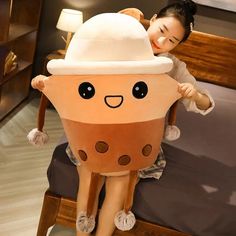 a woman sitting on top of a bed next to a giant stuffed animal wearing a hat