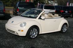 a white convertible car parked in a parking lot