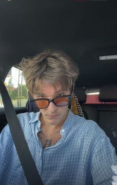 a woman wearing sunglasses sitting in the back seat of a car